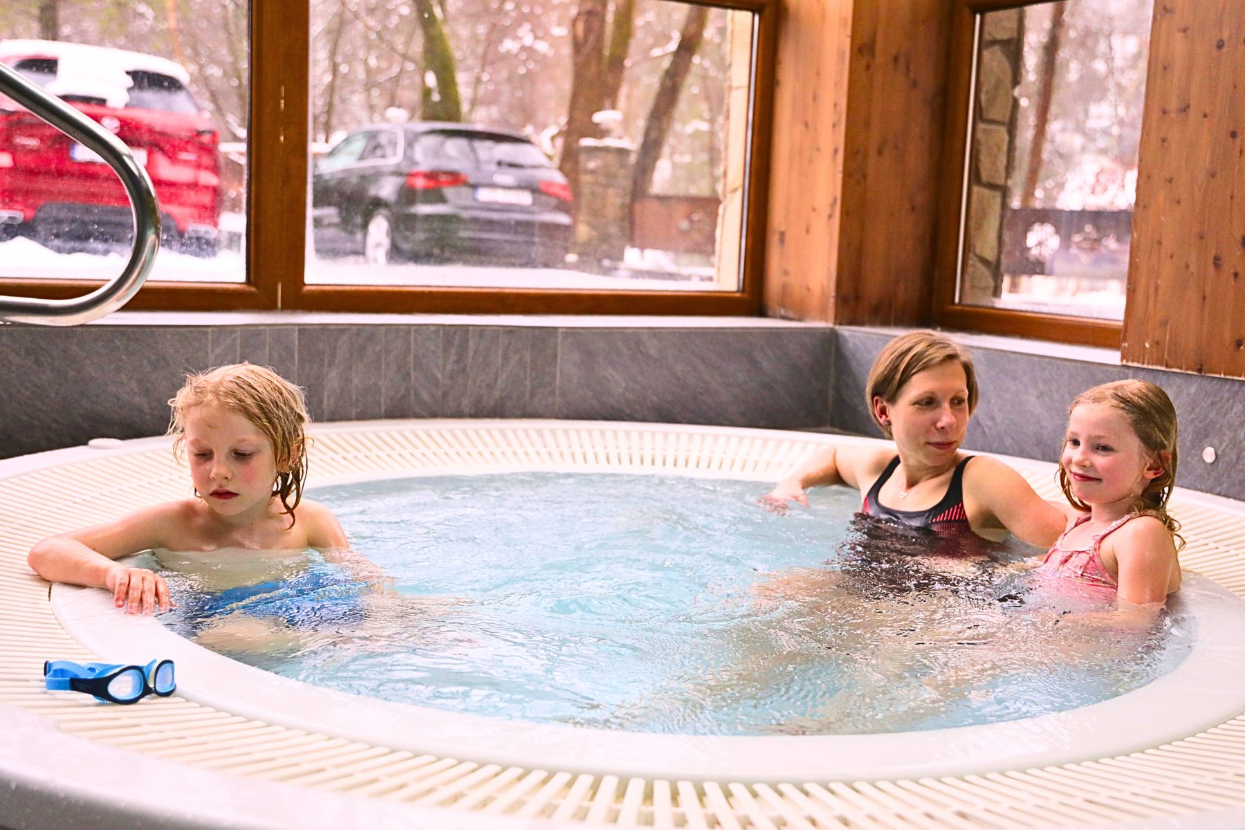 Dwoje dzieci i kobieta w jacuzzi wewnętrznym Hotelu Jawor, za oknami śnieg