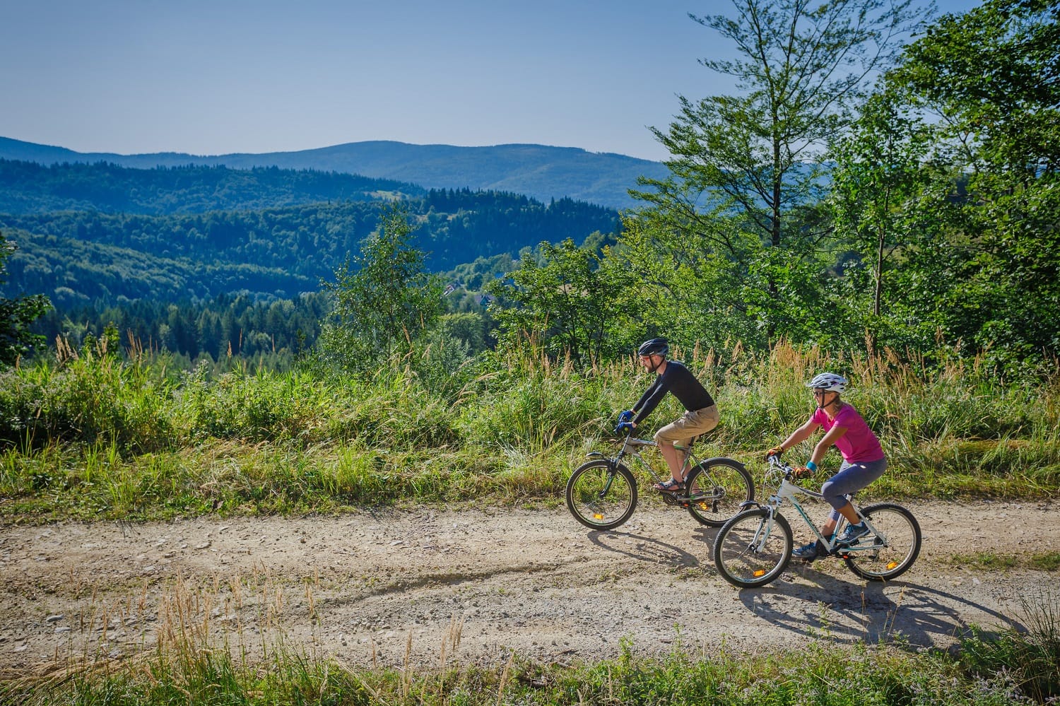 Rowerzyści na leśnej drodze nad Zawoją — aktywny wypoczynek w Beskidach.