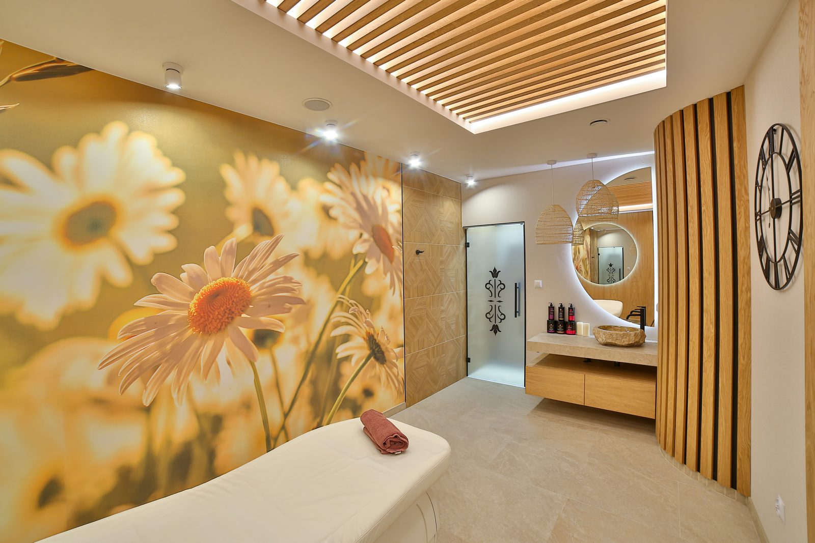 Gabinet Kwiatowy w SPA Hotelu Jawor — stół do zabiegów przy fototapecie z rumiankami, obok kabina prysznicowa
