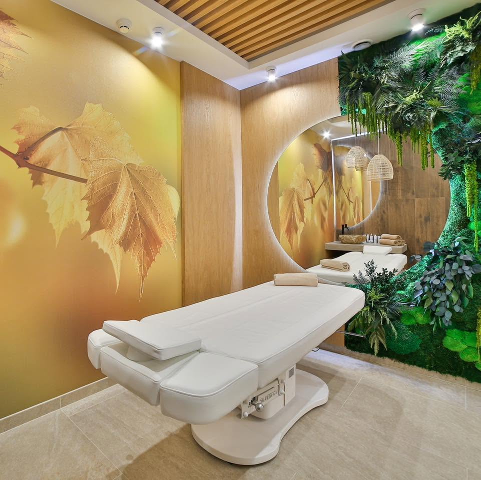 Gabinet zabiegowy SPA z jedną leżanką, ścianą z mchu i okrągłym lustrem