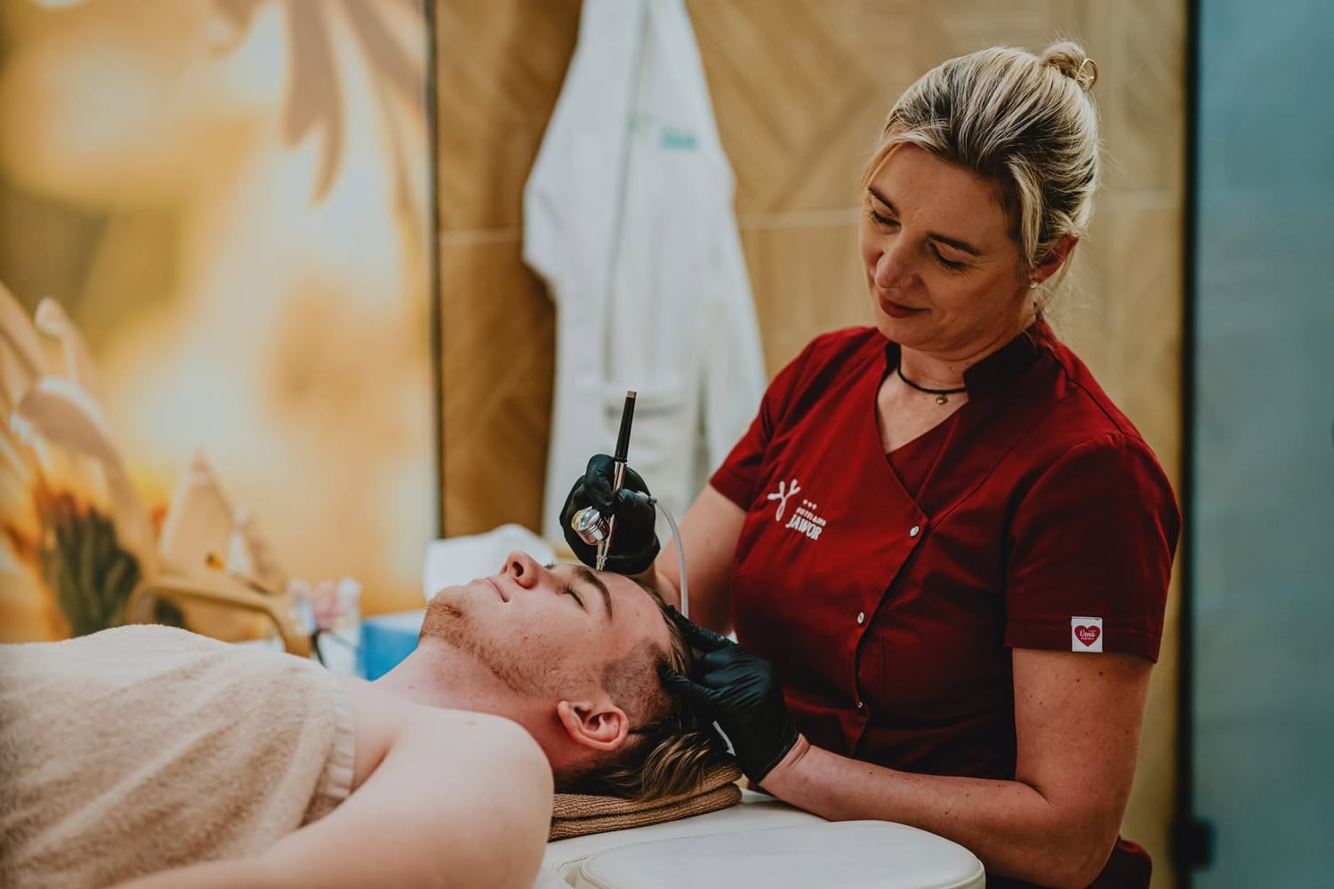 Zabieg na twarz w gabinecie SPA Hotelu Jawor — kosmetolożka przy jednym stole zabiegowym
