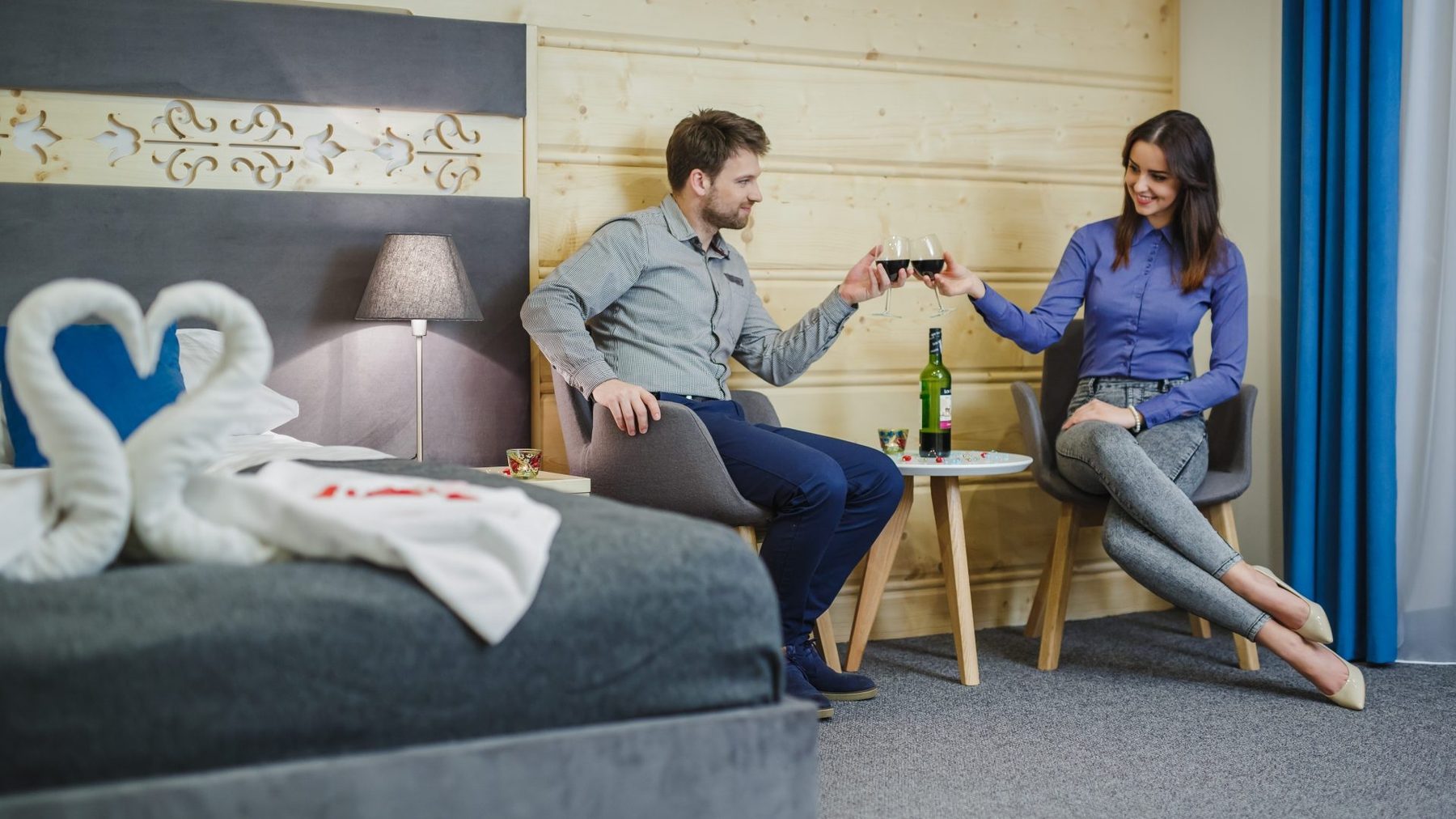 Para wznosząca toast w pokoju Willi Jawor, na łóżku łabędzie z ręczników