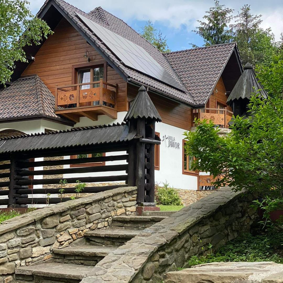 Willa Jawor od kamiennych schodów — drewniane balkony i szyld nad wejściem