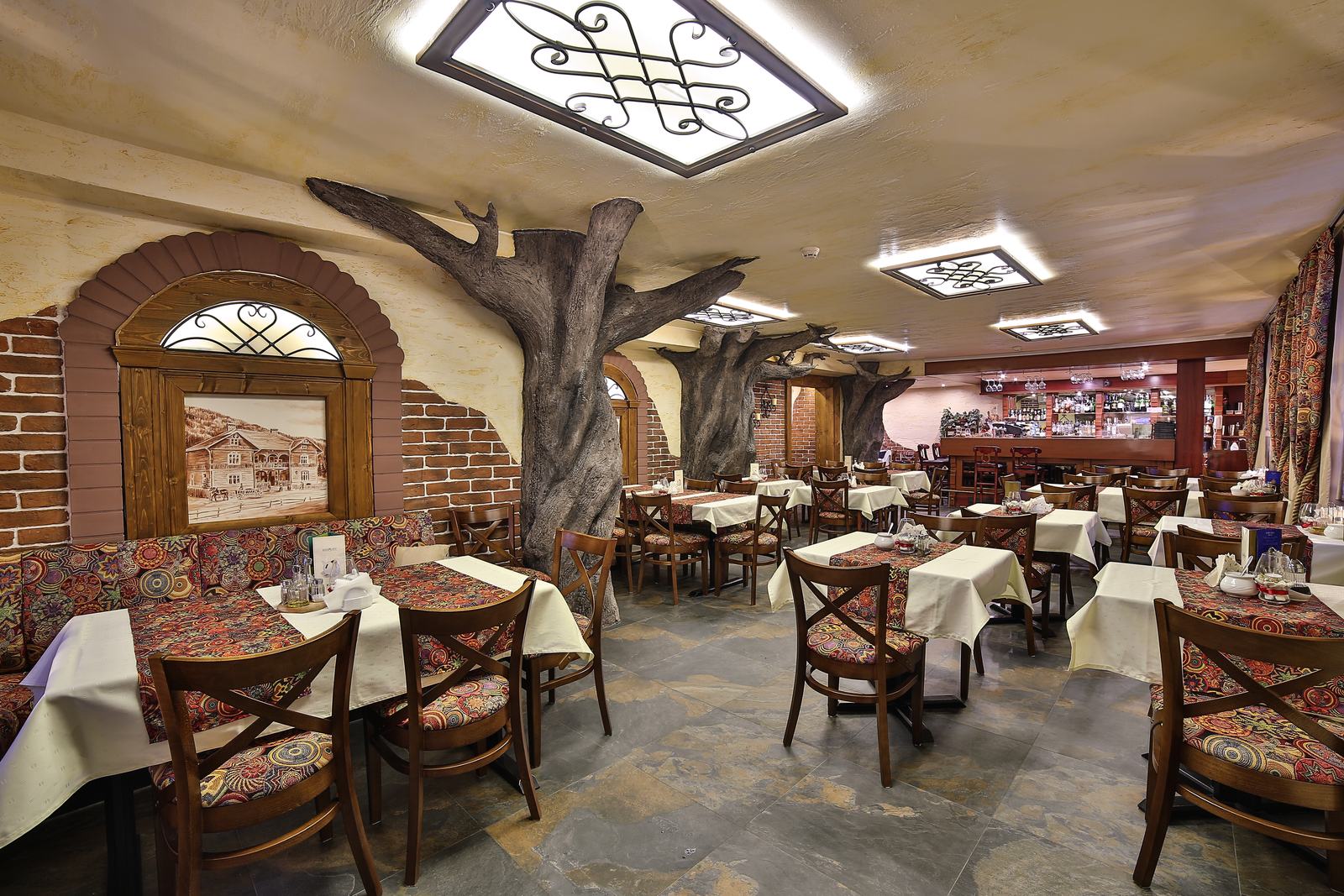 Sala restauracji Hotelu Jawor — nakryte stoły z góralskimi bieżnikami w ceglanym wnętrzu